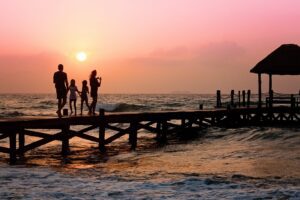 Family walking on pier during sunset