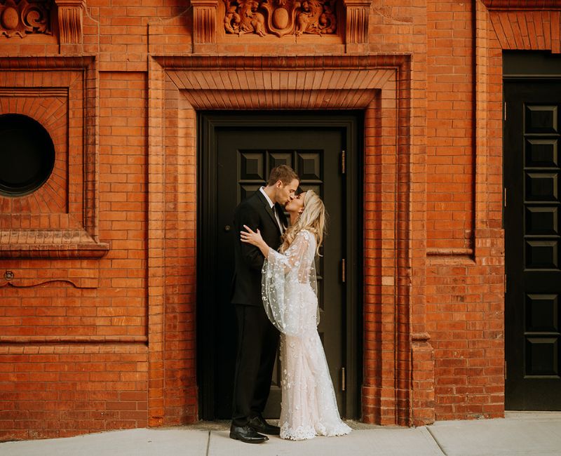 Bride and groom kissing outside the Goodwin